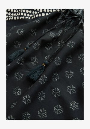 Tânără fabrică neagră cu modele geometrice albe. Dispune de un sistem de închidere cu șnur și ciucuri. Textură netedă, design ușor și accente detaliate.