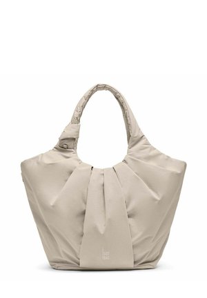 Sac fourre-tout en tissu beige doux avec poignée rembourrée, design plissé à l'avant et logo discret "GOT BAG" en bas au centre.