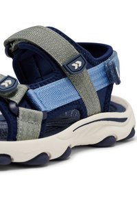 Marineblauwe en lichtblauwe sandaal met textuurriemen, verstelbare sluitingen en een gewatteerde zool met een wit- en marineblauw ontwerp.