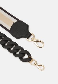 Svart flätad kedjeslinga med guldfärgad hårdvara, kompletterad med en randig tygsektion i krämfärgade och mörka nyanser med en texturerad läderpatch.
