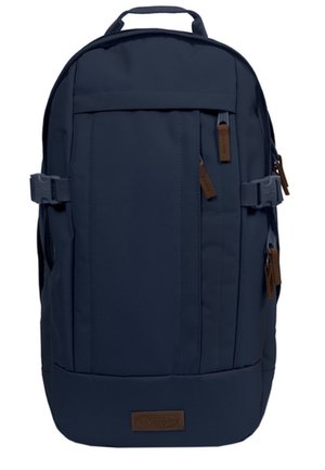 Sac à dos bleu foncé avec plusieurs compartiments zippés, sangles de compression latérales, une poignée supérieure et des tirettes de fermeture éclair marron ainsi qu'un patch logo.