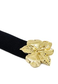 Cintura elastica nera con una grande chiusura floreale in oro testurizzato a cinque petali, che mette in risalto una finitura metallizzata lucida.