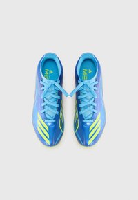 Blue sport shoes with light blue laces and yellow accents are displayed from above against a plain white background.