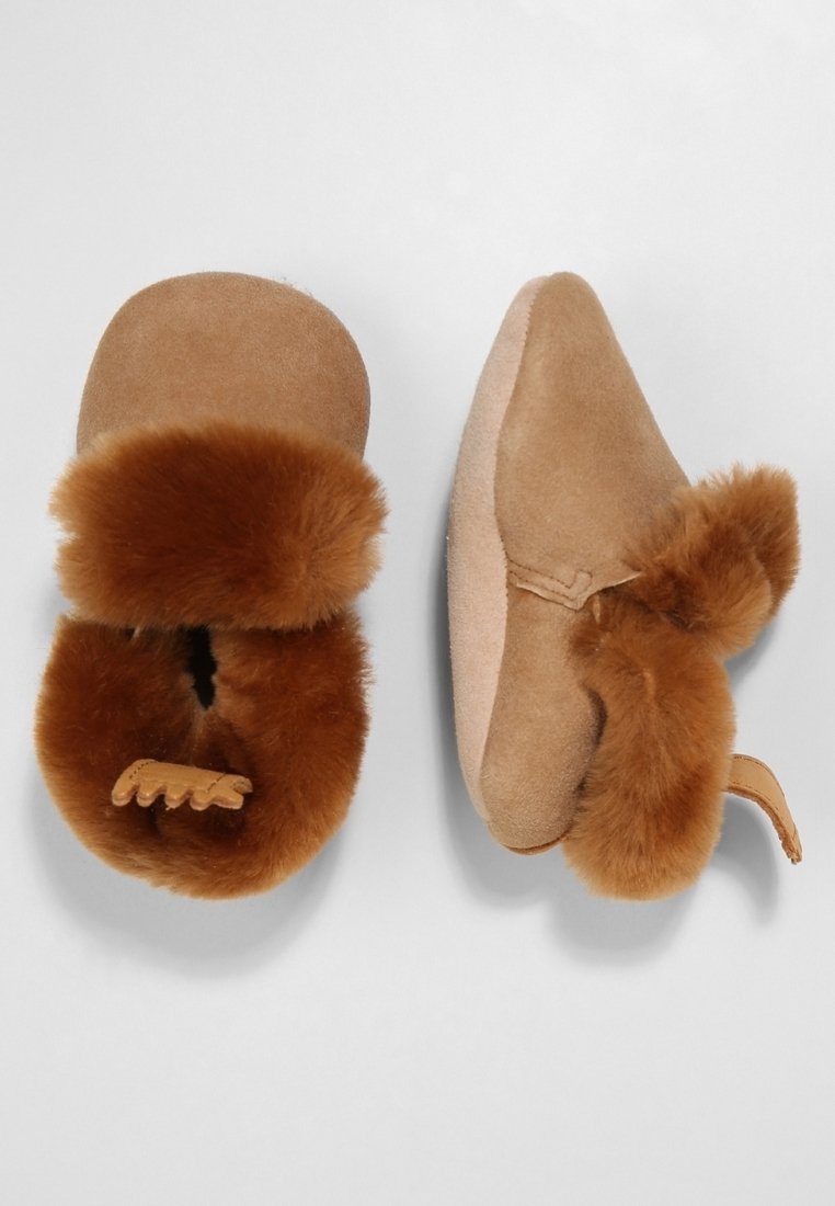 Chaussons en daim beige avec un doux revers en fourrure marron. Design à enfiler avec un bout arrondi et un accent en cuir décoratif à l'avant.