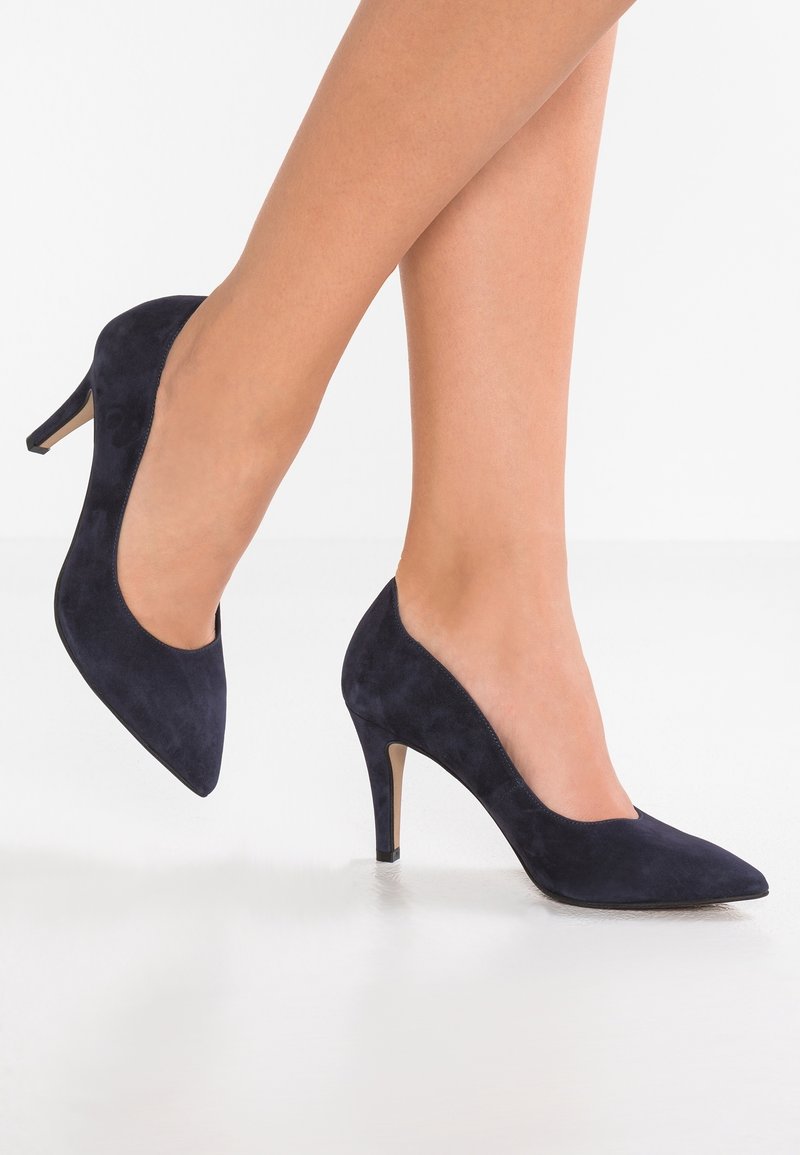 Escarpins en daim bleu marine à talons hauts avec un bout pointu et une silhouette élégante. Caractérisés par un talon aiguille fin et une texture lisse.