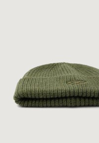 Berretto lavorato a maglia verde pieghevole con texture a coste; presenta un emblematico sottile sul davanti. Realizzato in un materiale morbido e caldo.