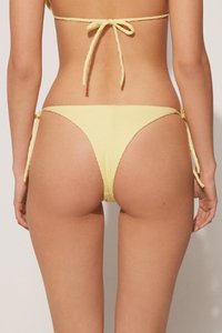 Yellow bikini bottom with textured fabric, adjustable side ties, and a Brazilian cut for minimal coverage.