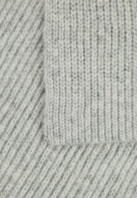 Gray knitted fabric featuring ribbed texture, showcasing varying shades and a soft feel, with a smaller piece of the same material layered above.