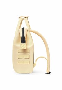 Yellow canvas backpack with a rounded shape, black zipper, and three horizontal webbing straps. Features a padded handle and shoulder strap.