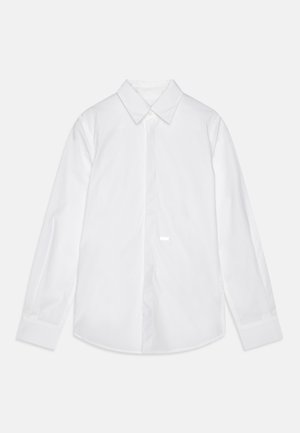 Valkoinen pitkähihaisen paita, joka on valmistettu puuvillasta. Siinä on klassinen kaulus, etupainike ja kaareva helma. Sujuva rakenne ilman näkyviä kuvioita.