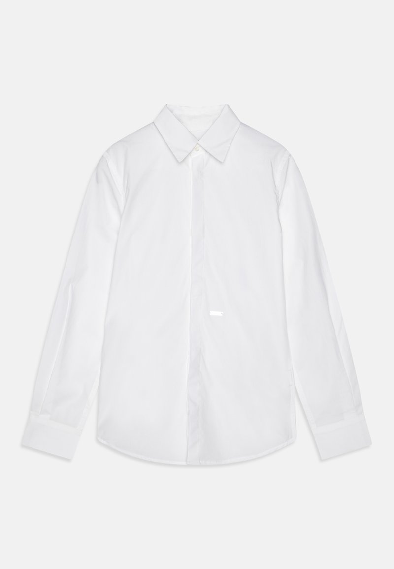 Camicia bianca a maniche lunghe in cotone. Presenta un colletto classico, bottoni frontali e un orlo arrotondato. Tessuto liscio senza motivi visibili.