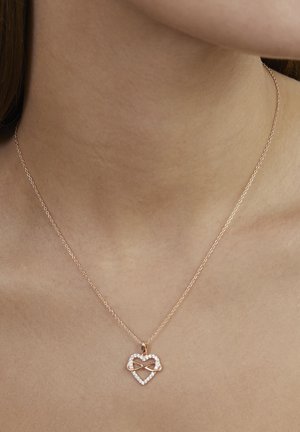 Halskæde i rosaguld med et hjertevedhæng, der har et infinity-symbol indeni, pyntet med klare krystaller rundt om kanten.