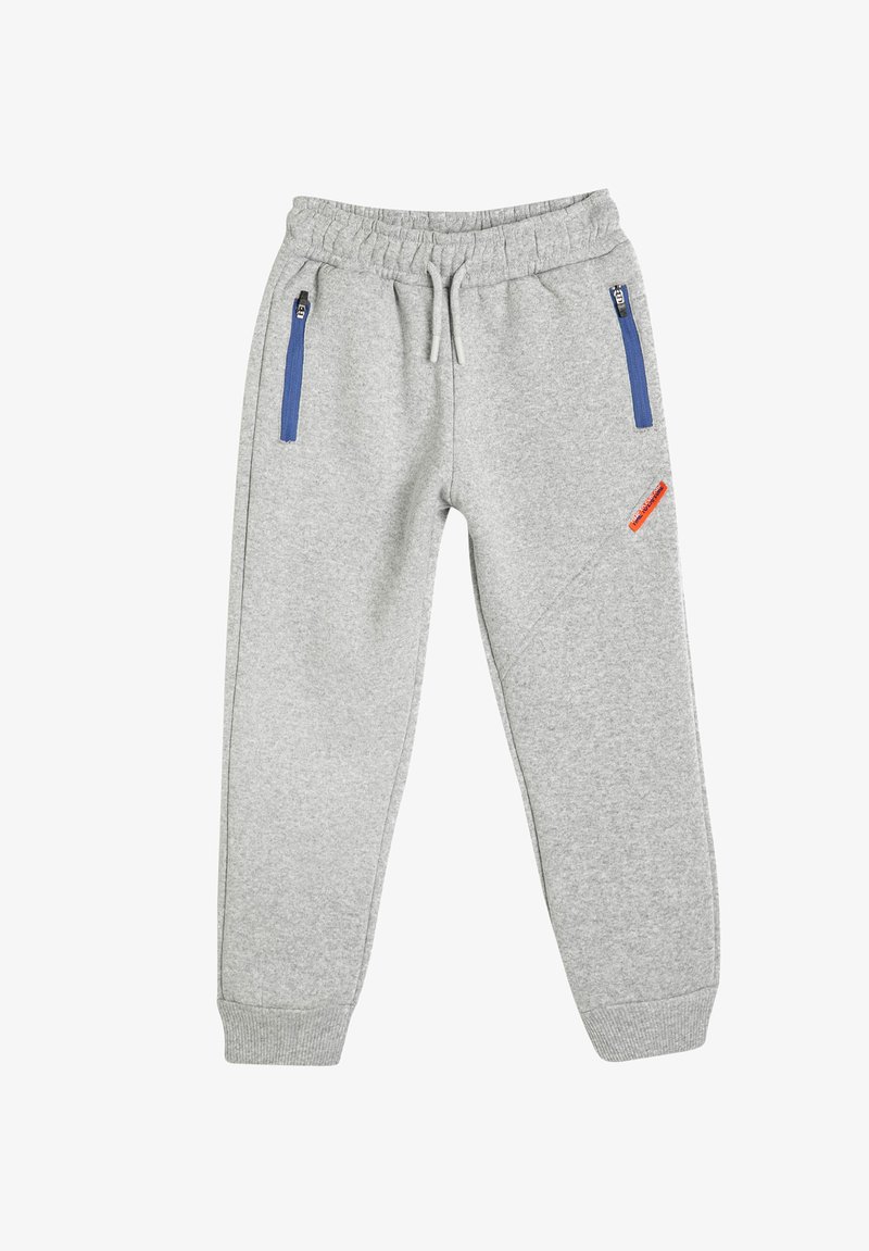 Graue Jogginghosen mit elastischem Bund, schmalem Schnitt, zwei blauen Reißverschlusstaschen und einem orangefarbenen Logopatch an der Seite. Weiches Material aus Baumwollmischung.