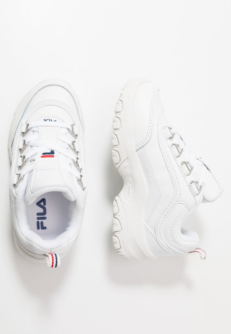 Baskets de sport blanches avec une tige en cuir synthétique, un col rembourré, un design à lacets, une semelle texturée et un accent rouge et bleu au niveau du talon.
