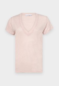 Jasnoróżowa koszulka z krótkim rękawem w kształcie litery V z miękkiej, lekko teksturowanej tkaniny, z małą metką marki wewnątrz kołnierza.