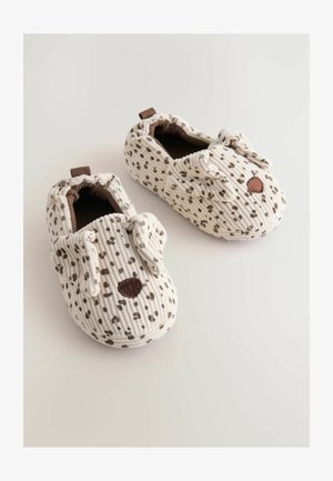 Pehmeät vauvan tossut, joissa on beige ja ruskea pilkullinen kuvio, ja jotka on suunniteltu roikkuvilla koiran korvilla sekä ruskealla nenällä etupuolella.