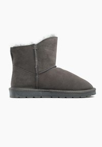 Stivale alla caviglia in suede grigio con una morbida fodera in shearling bianco, punta tonda, dettagli di cuciture rinforzate e suola in gomma bassa.