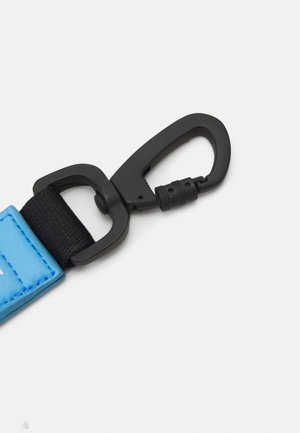 Blauwe leren band met een zwarte nylonsectie en een zwarte plastic clip, met een gladde textuur en een stevig ontwerp.