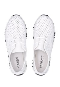 Weiße perforierte Sneaker mit runder Zehenform, Schnürdesign, schwarzen Akzenten und einer strukturierten Sohle. Markenlogo auf der Innensohle sichtbar.