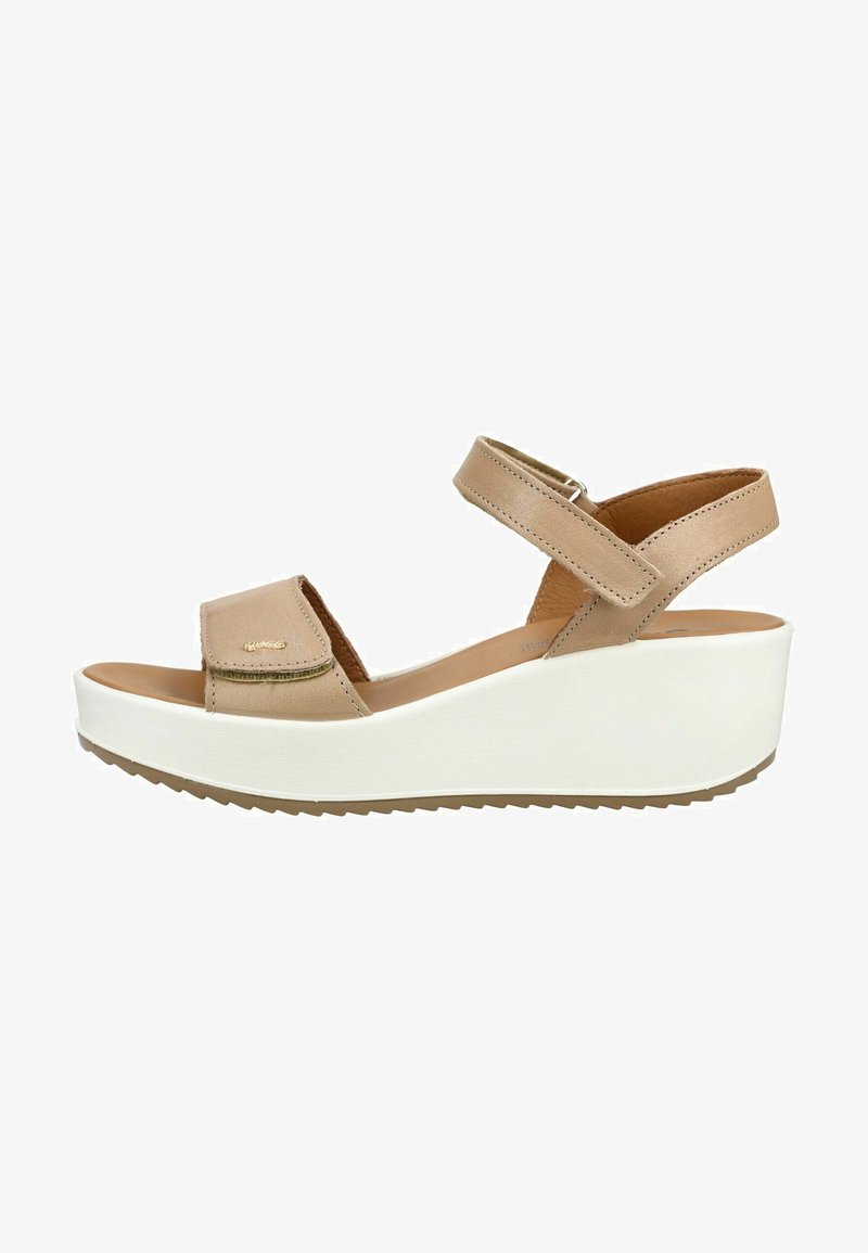 Sandale beige à talon compensé ouvert à l'avant, avec brides réglables en Velcro à la cheville et à l'avant, et une semelle plateforme blanche avec une bande de roulement texturée.