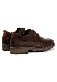 Zapatos de cuero marrón con punta redondeada, acabado suave, acentos en tono marrón claro contrastante y suelas de goma con un patrón de textura en la banda de rodadura.