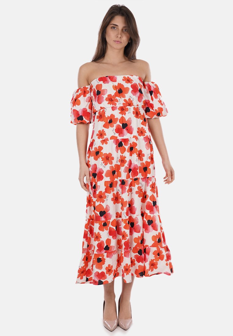 Abito maxi scivolato sulle spalle in tessuto bianco con motivo floreale in rosso, arancione e nero. Presenta maniche a sbuffo e strati a balze.