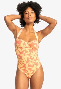 Én-delt badedragt med blomstermønster i bl�øde orange og gule nuancer, med halterneck-design og tekstureret stofdetalje.