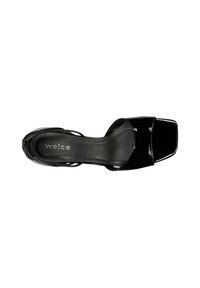 Sandal con tacco alto in pelle verniciata nera, punta quadrata, apertura sul dietro e sottili cinturini. La texture è liscia e lucida, con un design minimalista.
