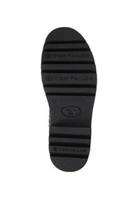 Semelle de chaussure en caoutchouc noir avec texture striée, inscription en relief "TOM TAILOR" et taille 40 marquée. Forme arrondie avec plusieurs lignes de crampons pour une meilleure adhérence.