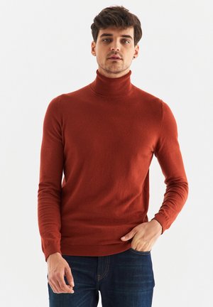 Rdzaworudy sweter typu golf z miękkiego materiału, z długimi rękawami, dopasowanym krojem oraz prążkowanym kołnierzem i dołem.