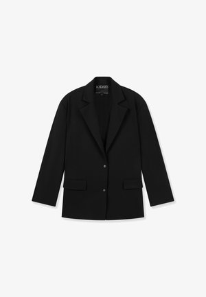 Veste blazer noire ajustée avec col à revers, deux poches avant à rabat et deux boutons-pression, posée à plat sur un fond blanc.