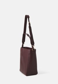 Sac à épaule en cuir bordeaux avec une forme rectangulaire structurée, doté d'une sangle ajustable et d'accents en matériel doré.