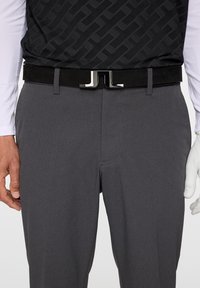 Szare spodnie teksturowane w połączeniu z czarnym zamszowym paskiem z błyszczącą srebrną klamrą oraz geometrycznym wzorem na czarnej górze.