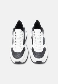 Baskets noir et blanc en cuir lisse et tissu texturé. Modèle à lacets avec une bande blanche contrastante et un logo embossé.