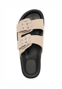 Beige mockasinsandaler med två justerbara remmar, silverfärgade spännen och en svart strukturerad sula. Platt sula designad för komfort och stabilitet.