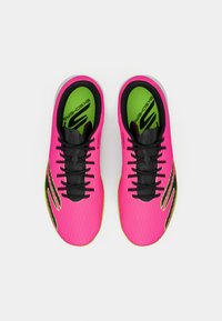 Pár jasně růžových sportovních bot Skechers s černými tkaničkami a neonově zelenými stélkami, pohled shora na bílém pozadí.