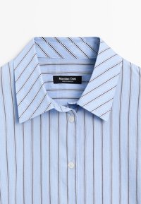 Light blue striped shirt with a crisp collar, featuring thin black stripes and two round buttons. Label reads "Massimo Dutti."