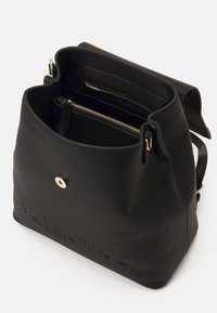 Svart läderhandväska med strukturerad yta, utrustad med magnetisk knappstängning, guldfärgade detaljer och flera inre fack.