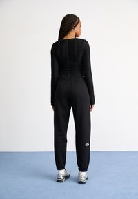The North Face ESSENTIAL JOGGER - Pantalones deportivos - black