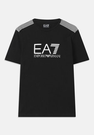 T-shirt en coton noir avec un logo EA7 blanc et le texte 'Emporio Armani'. Trois rayures blanches sur les épaules rehaussent le design.