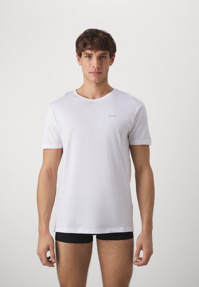 White cotton t-shirt with short sleeves, round neckline, and a small dark logo embroidered on the chest, worn over black briefs.