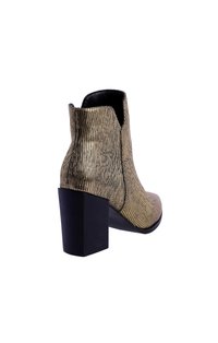 Botín de tobillo metálico dorado con una superficie texturizada, puntera afilada y un tacón negro en bloque. Acabado interior suave, diseño minimalista.