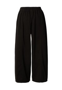 Pantalon noir à jambes larges avec ceinture élastique, coutures droites et coupe ample, présenté sur un fond blanc.