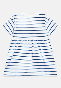 Vit kortärmad klänning för små barn med blå horisontella ränder och gathered midja, visad bakifrån på en neutral bakgrund.