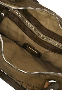 Interno di una borsa a tracolla in pelle verde scuro con scomparti con cerniera. Fodera in tessuto morbido, caratterizzata da una texture liscia e dettagli di cuciture a contrasto.