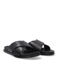 Zwarte leren slidersandalen met gekruiste bandjes, platte zool en minimalistisch ontwerp. Gladde textuur met een matte afwerking.
