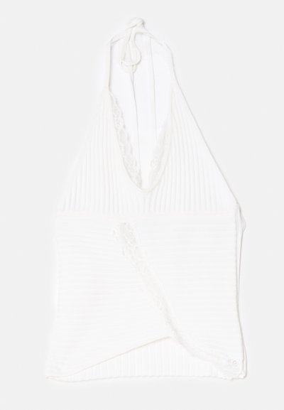 Haut à bretelles blanc en tissu côtelé, avec une dentelle le long de l'encolure et un design enveloppant à la taille.