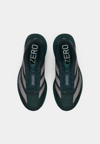 Baskets de sport vertes et grises avec une partie supérieure en maille, dotées d'une zone de orteil texturée, d'un talon renforcé et du logo "ADIZERO" sur la languette.
