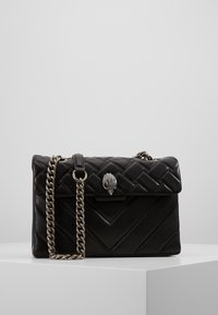 Borsa a tracolla in pelle trapuntata nera con catena argentata e chiusura decorativa. Presenta motivi a zig-zag e una finitura liscia.