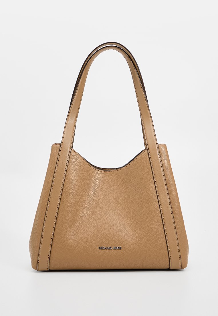 Tote-väska i tan färgad pebble-läder med en slapp form, dubbla handtag och en subtil logotyp. Har rena linjer och en texturerad yta.